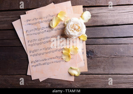 Schöne Rose auf Musik Blätter auf Holz- Hintergrund Stockfoto