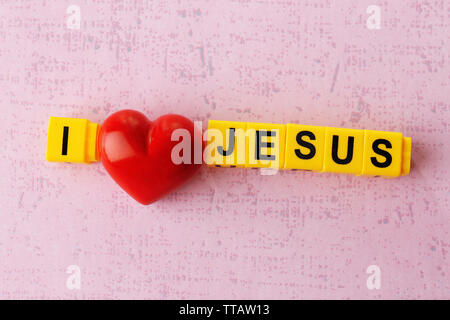 Ich liebe Jesus Zeichen mit bunten Kunststoff Buchstaben auf Rosa strukturierten Hintergrund dargestellt Stockfoto
