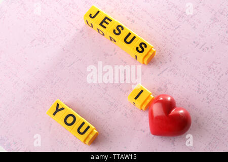 Ich liebe Jesus Zeichen mit bunten Kunststoff Buchstaben auf Rosa strukturierten Hintergrund dargestellt Stockfoto