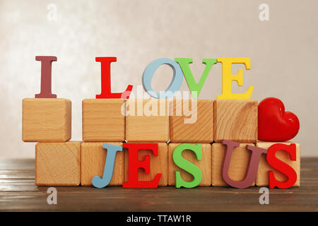 Ich liebe Jesus Zeichen mit bunten Kunststoff Buchstaben auf dem Holztisch auf Licht strukturierten Hintergrund dargestellt Stockfoto