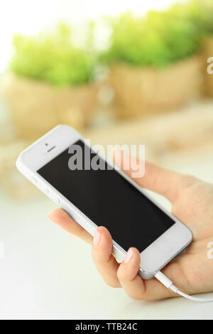 Musik Smartphone in weiblicher Hand, auf hellen Hintergrund Stockfoto