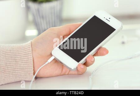 Musik Smartphone in weiblicher Hand, auf hellen Hintergrund Stockfoto