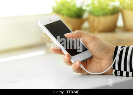 Musik Smartphone in weiblicher Hand, auf hellen Hintergrund Stockfoto