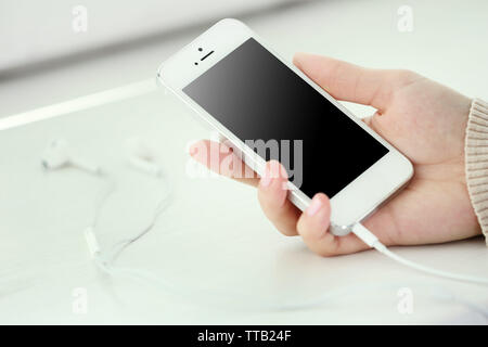 Musik Smartphone in weiblicher Hand, auf hellen Hintergrund Stockfoto