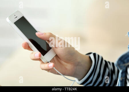 Musik Smartphone in weiblicher Hand, auf hellen Hintergrund Stockfoto
