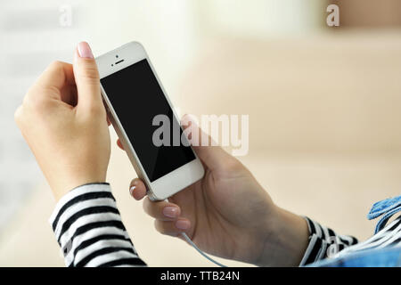 Musik Smartphone in weiblicher Hand, auf hellen Hintergrund Stockfoto
