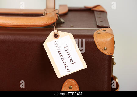 Koffer mit Travel Insurance Label, Nahaufnahme Stockfoto