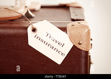 Koffer mit Travel Insurance Label, Nahaufnahme Stockfoto
