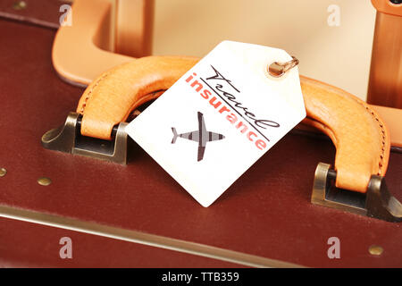 Koffer mit Travel Insurance Label, Nahaufnahme Stockfoto