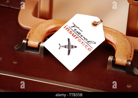 Koffer mit Travel Insurance Label, Nahaufnahme Stockfoto