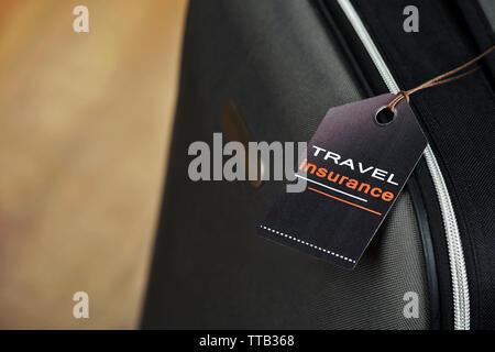 Koffer mit Travel Insurance Label, Nahaufnahme Stockfoto