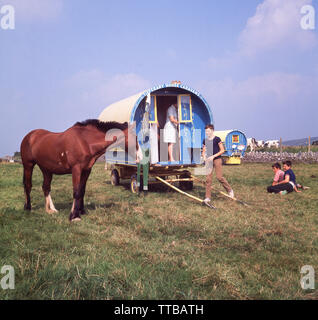 1960, historische, Kinder außerhalb ihrer Sommerurlaub home, Tipperary Pferd Caravan, einem traditionellen Bogen gypsy Wagen in einem Feld zu Swanston farm geparkt, in der Nähe von Edinburgh, Schottland. Ein altes Dorf, Swanston ist überwiegend ländlich, aber in der Nähe der Wohngebiete der schottischen Stadt. Stockfoto