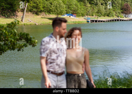 Junge Paare wollen ein Foto von Ihnen von einem Touristen zu nehmen, aber unerfahrene und das Bild wird unscharf und zerlegt Stockfoto