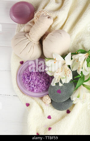 Massage Taschen mit Wellnessbehandlungen und Blumen auf hölzernen Tisch Hintergrund Stockfoto