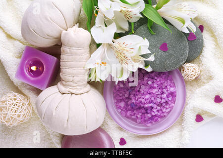 Massage Taschen mit Wellnessbehandlungen und Blumen auf hölzernen Tisch Hintergrund Stockfoto