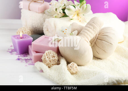 Massage Taschen mit Wellnessbehandlungen und Blumen auf hölzernen Tisch Hintergrund Stockfoto