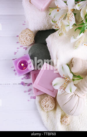 Massage Taschen mit Wellnessbehandlungen und Blumen auf hölzernen Tisch Hintergrund Stockfoto