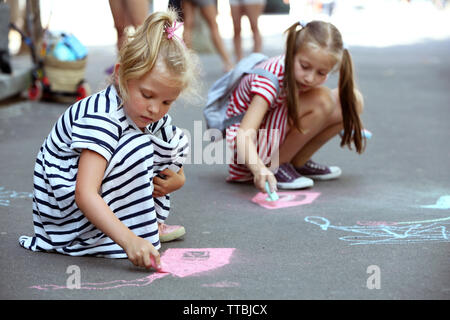 Gerne aktive Kinder Zeichnen mit Kreide auf Asphalt Stockfoto