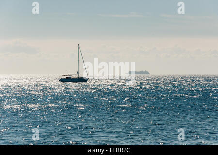 Kreuzfahrt Schiff und einem kleinen Segelboot auf offener See Stockfoto