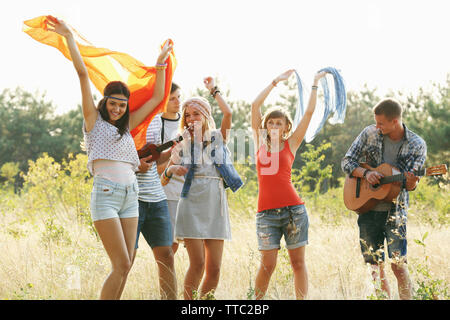 Freudiges Lächeln Freunde tanzen im Wald im Freien Stockfoto