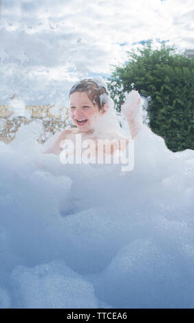 3 Jahre Junge genießen Schaum Party im Freien. Aktive Freizeit im Sommer Saison für Kinder Stockfoto