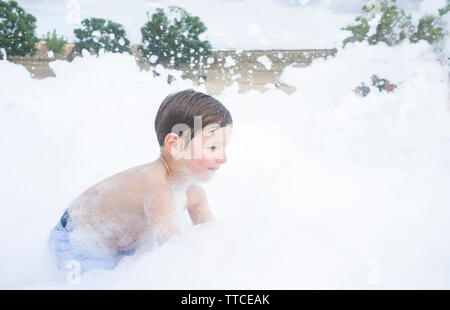 3 Jahre Junge genießen Schaum Party im Freien. Aktive Freizeit im Sommer Saison für Kinder Stockfoto