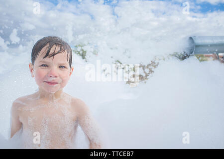 3 Jahre Junge genießen Schaum Party im Freien. Aktive Freizeit im Sommer Saison für Kinder Stockfoto