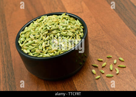 Fenchel Samen in einem schwarzen Schale auf Holztisch. Stockfoto