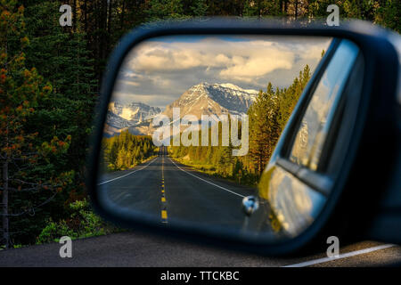 Ein Auto durch einen Berg Straße, die durch die Kanadischen Rocky Mountains führt und die schöne Landschaft im Rückspiegel in der icefiel Stockfoto