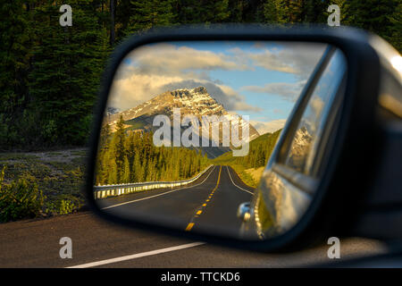 Ein Auto durch einen Berg Straße, die durch die Kanadischen Rocky Mountains führt und die schöne Landschaft im Rückspiegel in der icefiel Stockfoto