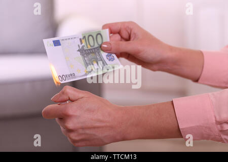 Frau brennen Euro im Zimmer Stockfoto