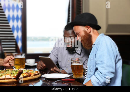Junge Männer trinken Bier und Gespräch im Cafe Stockfoto