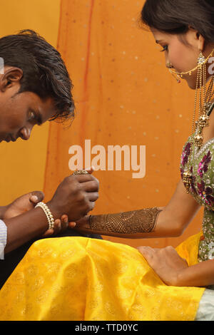 Männliche Künstler Mehendi auf eine Braut Hand anwenden Stockfoto
