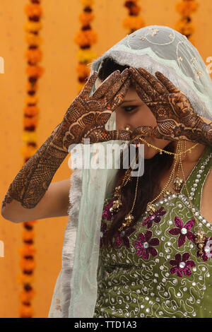 Indische Braut zeigt ihre Handflächen mit Mehendi geschmückt Stockfoto