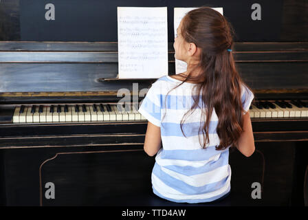 Süße kleine Musiker Mädchen spielt Klavier, Rückansicht Stockfoto