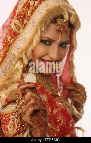 Porträt einer indischen Braut zeigt Silbermünze Stockfoto