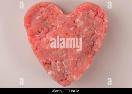 Saftig frischem Hackfleisch patty auf eine beige Platte. Ist alles fertig, ein komplettes Protein Ernährung vorzubereiten. Stockfoto