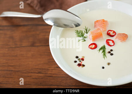 Lecker lachs Rahm Suppe mit Löffel auf Holztisch, Nahaufnahme Stockfoto