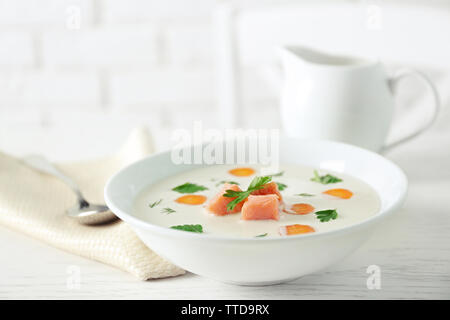 Leckere Cremesuppe mit Lachs und Karotten in weiße Schüssel Stockfoto