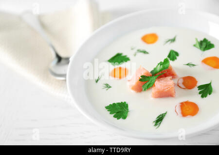 Leckere Cremesuppe mit Lachs und Karotten in weiße Schüssel Stockfoto