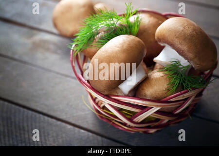 Pilze im Korb auf Holz- Oberfläche Stockfoto