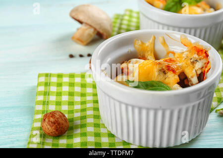 Französische Gericht Julienne. Pilz, Hühnchen und Käse überbacken in Keramik Schalen, auf hölzernen Hintergrund Stockfoto