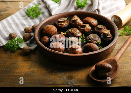 Gebackene champignons Pilze mit Butter, Petersilie und Knoblauch gebraten in brauner Schale Stockfoto