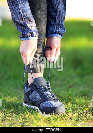 Frau in Sportbekleidung sneakers Schnürsenkel binden Outdoor close-up Stockfoto