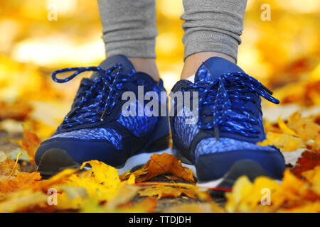 Woman's Beine in die Schuhe auf einem Hintergrund Laub Stockfoto