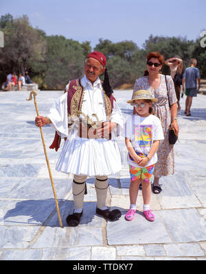 Mann im traditionellen griechischen Kleid mit Touristen, Plaka Athen (Athina), Athen, Griechenland Stockfoto