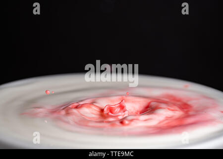 Spritzer Milch Tröpfchen in Nahaufnahme makro High Resolution gegen einen schwarzen Hintergrund isoliert Stockfoto