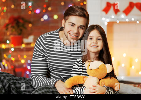 Der ältere Bruder mit kleinen Schwester in Weihnachten Wohnzimmer sitzen Stockfoto