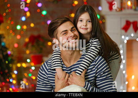 Der ältere Bruder mit kleinen Schwester umarmen in Weihnachten Wohnzimmer Stockfoto