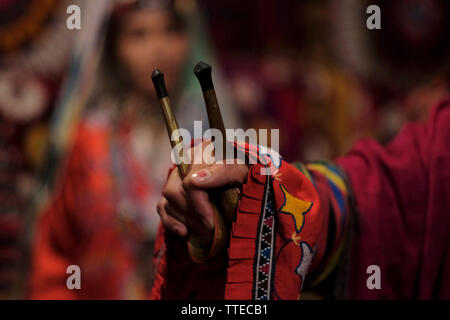 Eine usbekische Frau in traditioneller Kleidung aus der Region Surkhandarya nahe der südlichen Grenze zu Tadschikistan, die Holzlöffel für rhythmische Percussion verwendet, um den „Raqs-e Koshik“ oder den Löffeltanz in Usbekistan zu begleiten Stockfoto